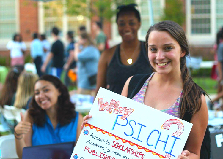 psychology student holding a Psi Chi sign